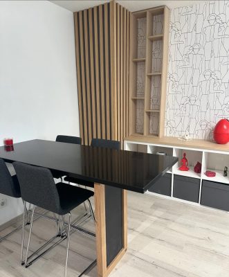 Agencement sur mesure d’un salon et coin repas Airbnb avec tasseaux et éléments en chêne