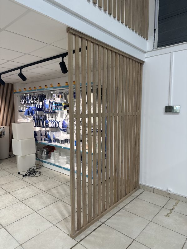 Claustra ajouré en tasseaux de chêne sur mesure dans le magasin JPL Piscines