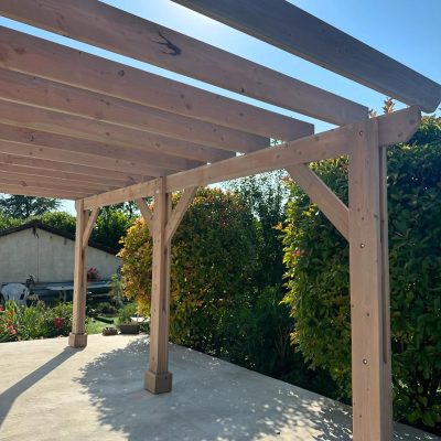 Pergola en bois adossée à trois poteaux de 6 mètres par 3,5 mètres